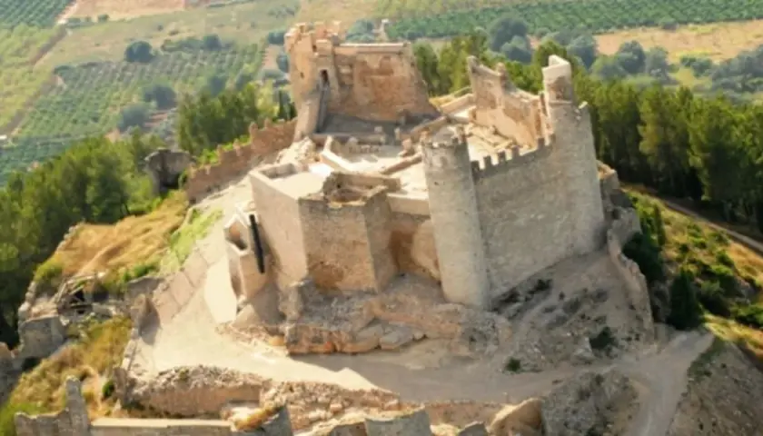 El imponente castillo de Xivert se alza sobre una colina, rodeado de vegetación y campos cultivados. Sus ruinas cuentan historias de batallas y tiempos pasados.