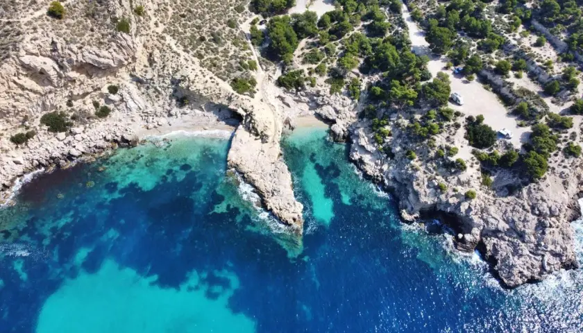 Vista aérea del racó del conill, una cala escondida con aguas cristalinas y rocas escarpadas.
