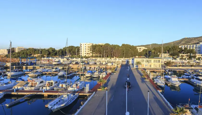 El puerto deportivo Las Fuentes, con sus barcos amarrados y el mar azul, se extiende bajo un cielo despejado.