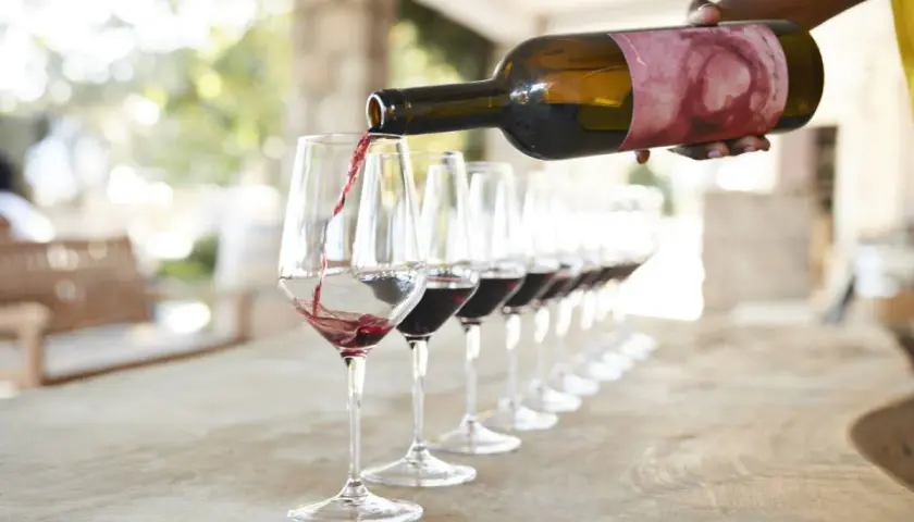 Una persona sirve vino tinto en copas para una degustación en Valencia.