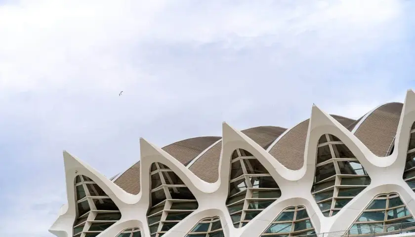 El Museo de las Ciencias de Valencia, con su arquitectura futurista y sus ventanas en forma de ojo, se alza bajo un cielo nublado.