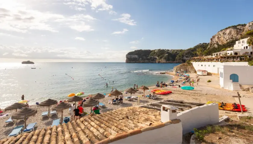 La cala Barraca, con su playa de guijarros, aguas cristalinas y acantilados, es un paraíso para disfrutar del sol y el mar. Kayaks y sombrillas invitan al descanso.