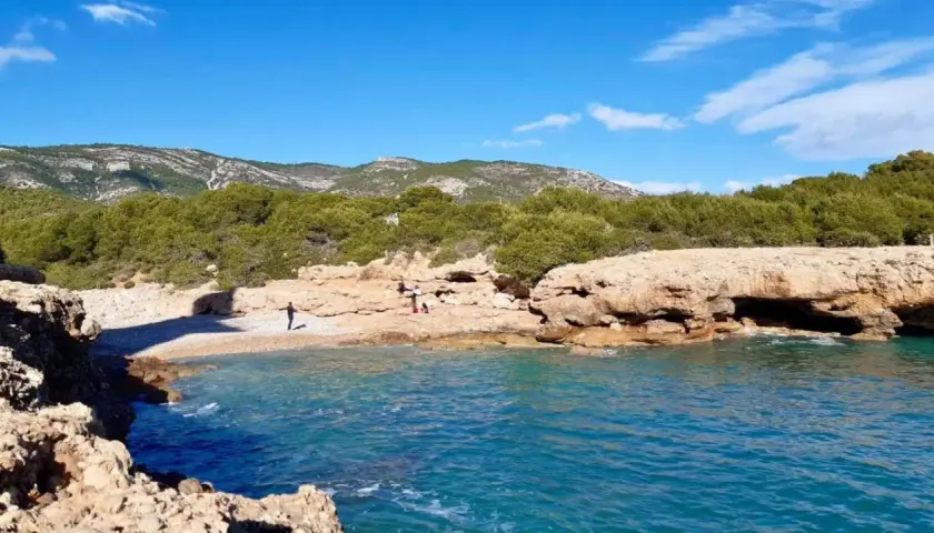 La cala mundina, con sus aguas turquesas y rocas doradas, invita a disfrutar de un día soleado. Un rincón idílico para desconectar.