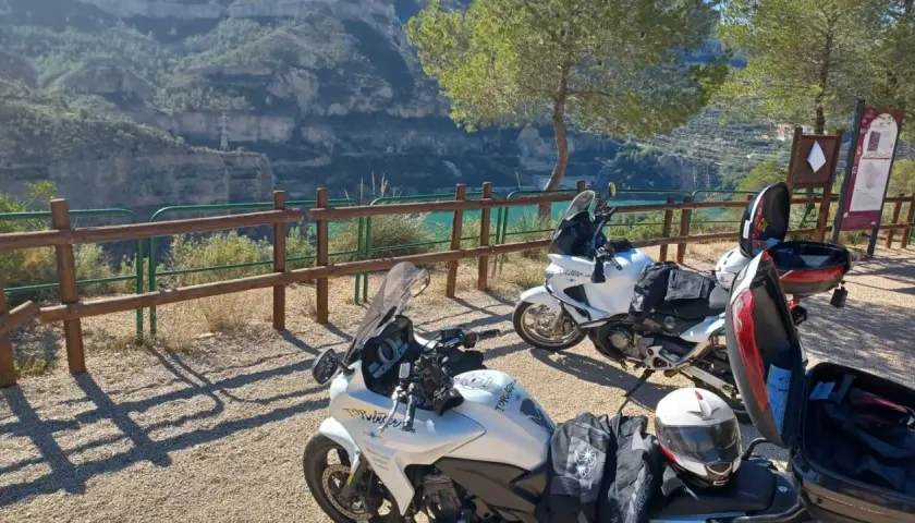 Dos motos blancas listas para explorar las **rutas en moto Comunidad Valenciana**, con un paisaje de cañón y embalse al fondo.