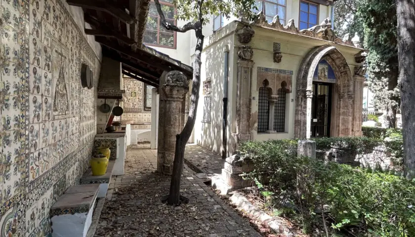 El patio de la casa museo Benlliure, con sus azulejos coloridos, bancos de piedra y un árbol frondoso, invita a pasear.
