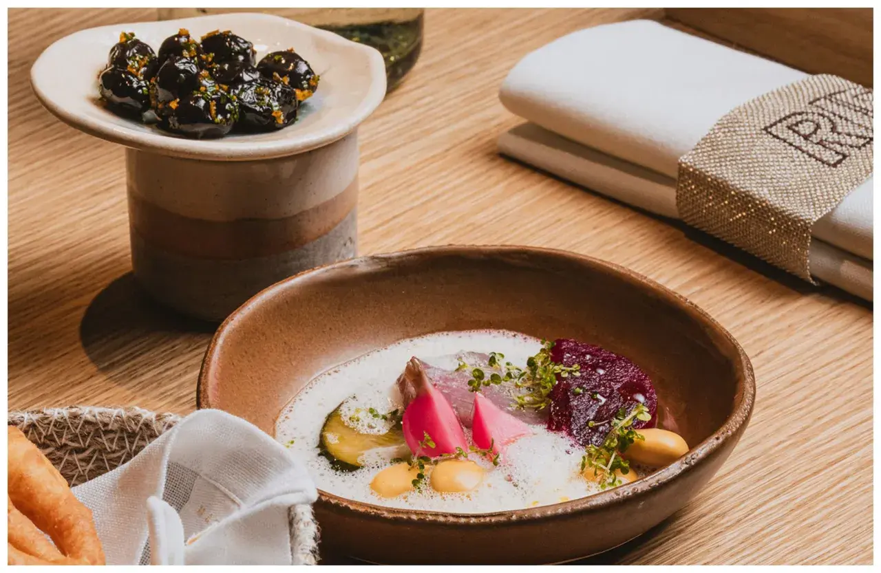 Plato de pescado con remolacha y espuma, aceitunas marinadas. ¡Una delicia para saber qué comer en Valencia!