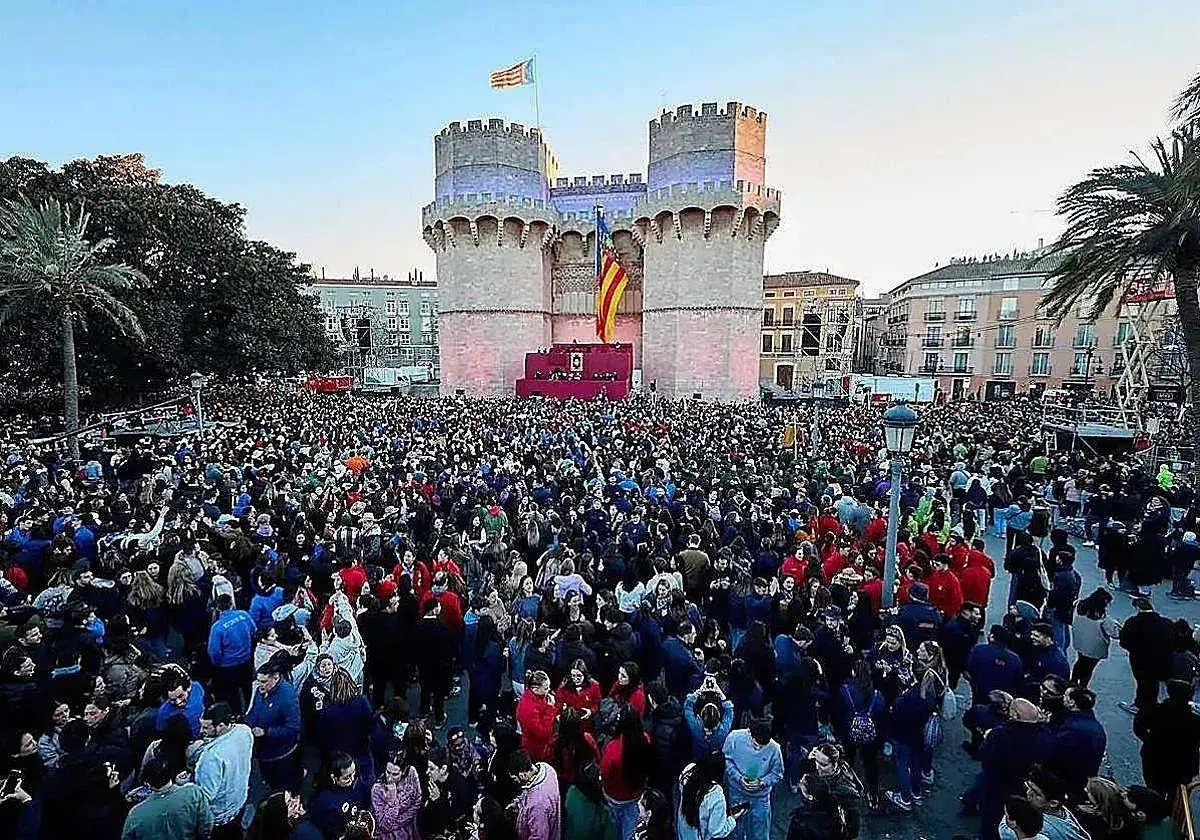 Multitudinaria **la crida valencia** ante las Torres de Serranos, con banderas valencianas ondeando y un escenario preparado.