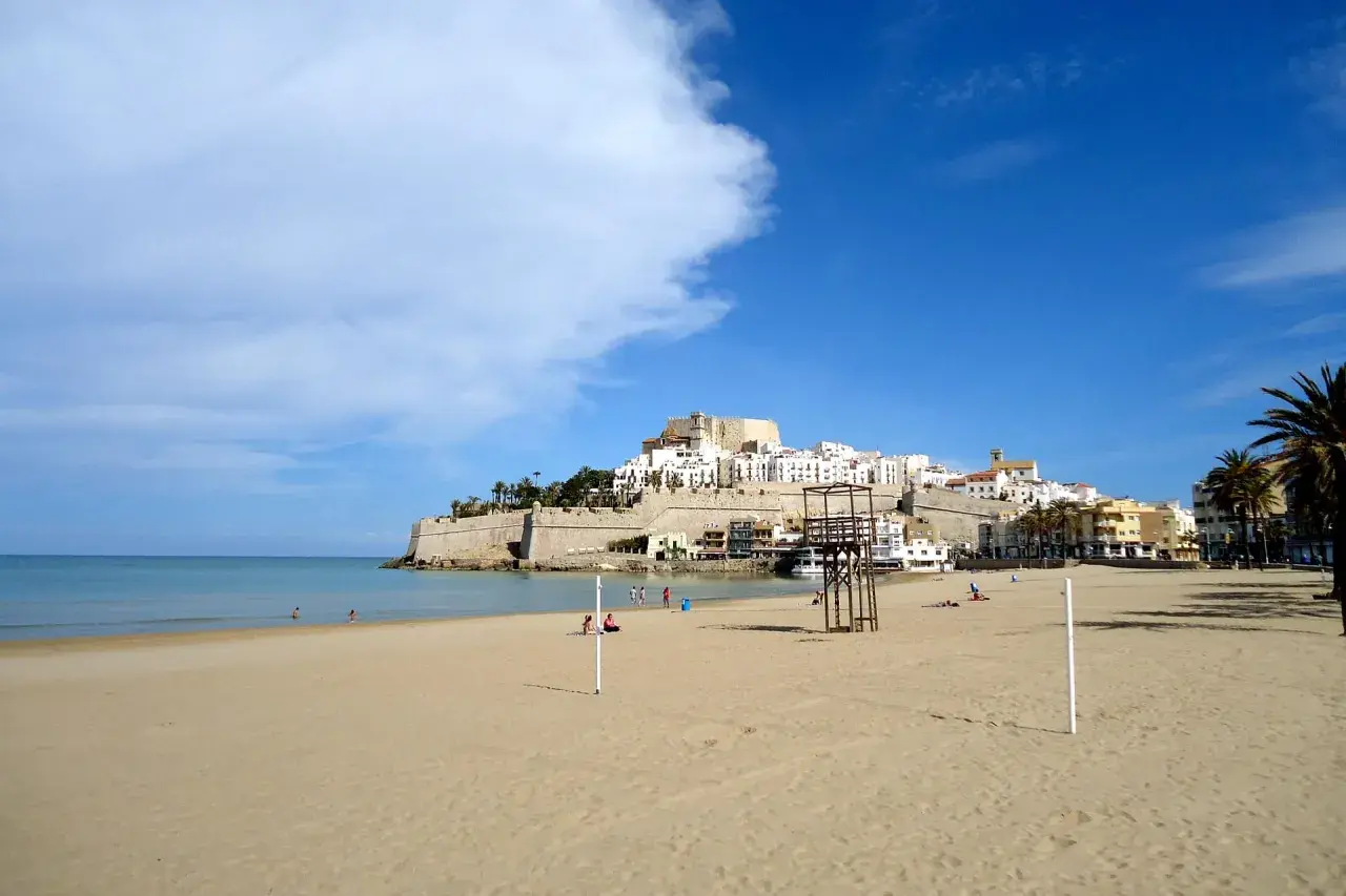 Playa de Peñíscola, con su imponente castillo y casitas blancas, se alza sobre el mar Mediterráneo. Un día soleado en el grao de Castellón.