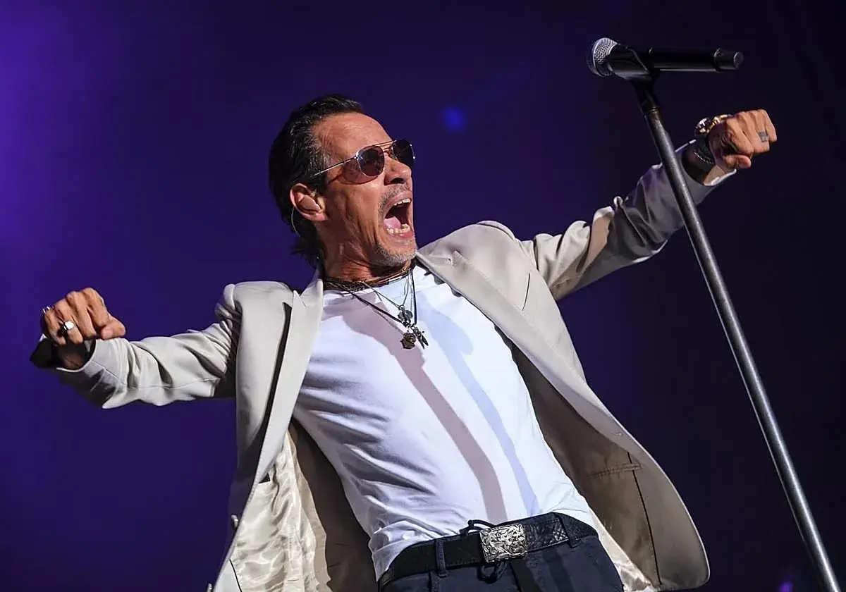 Marc Anthony canta con pasión en su concierto de Valencia, con los brazos extendidos y la boca abierta.