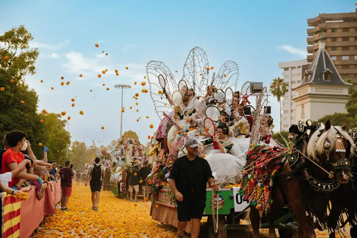 La batalla de las flores Valencia en pleno apogeo. Carrozas adornadas, gente lanzando flores y un ambiente festivo.
