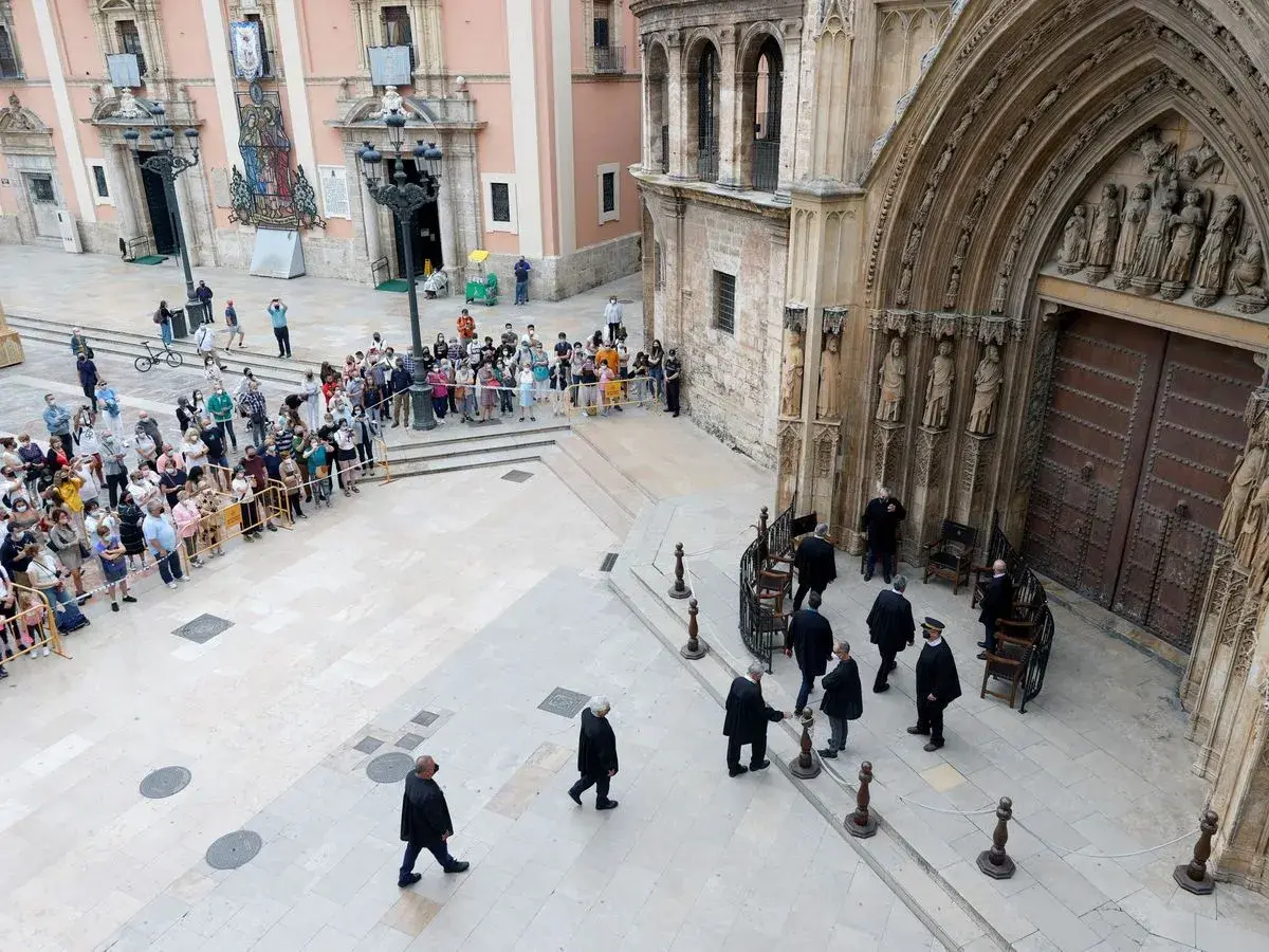Hombres con togas se reúnen ante la puerta de la Catedral de Valencia, donde se celebra el tribunal de las aguas de Valencia.