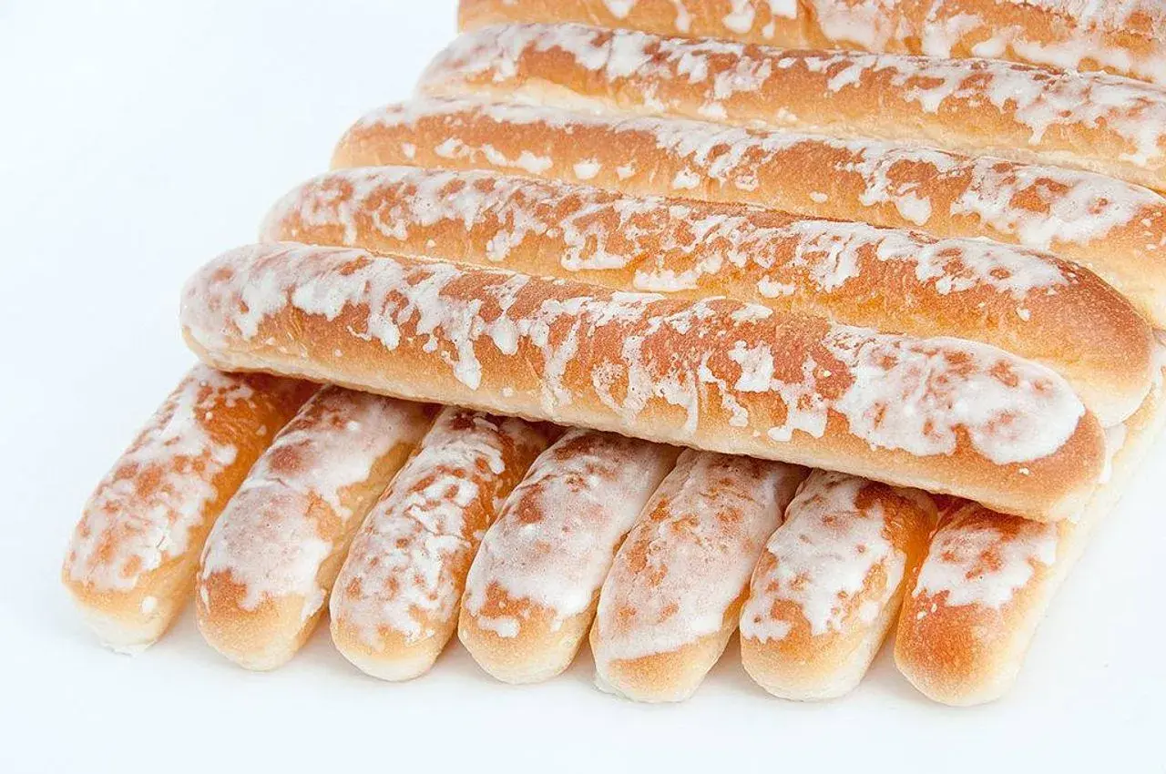 Dulces típicos de Valencia: barritas doradas cubiertas de glaseado blanco, apiladas en una pirámide.