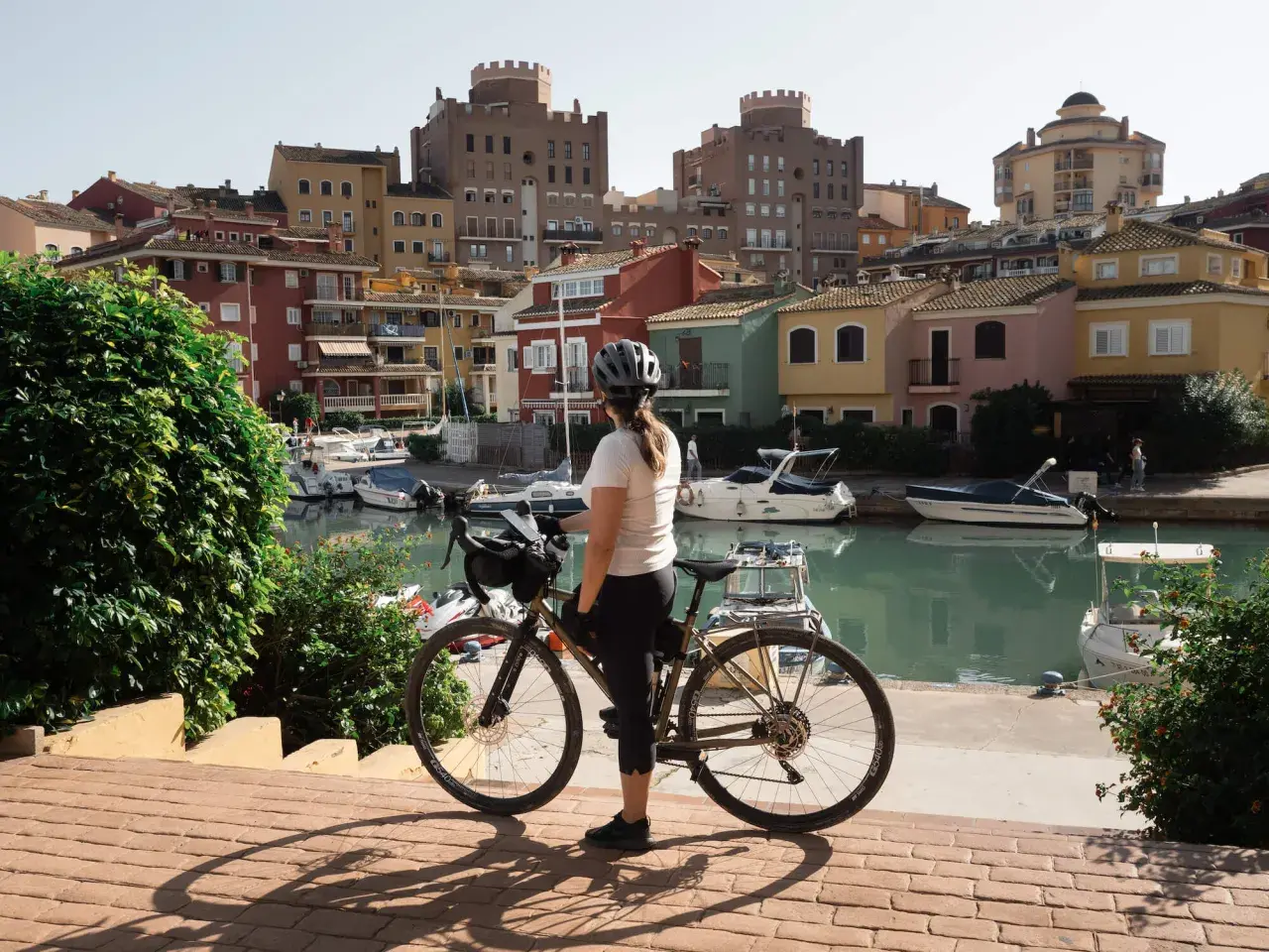 Ciclista en Valencia, disfrutando de las rutas ciclistas junto a un canal con casas coloridas y barcos.