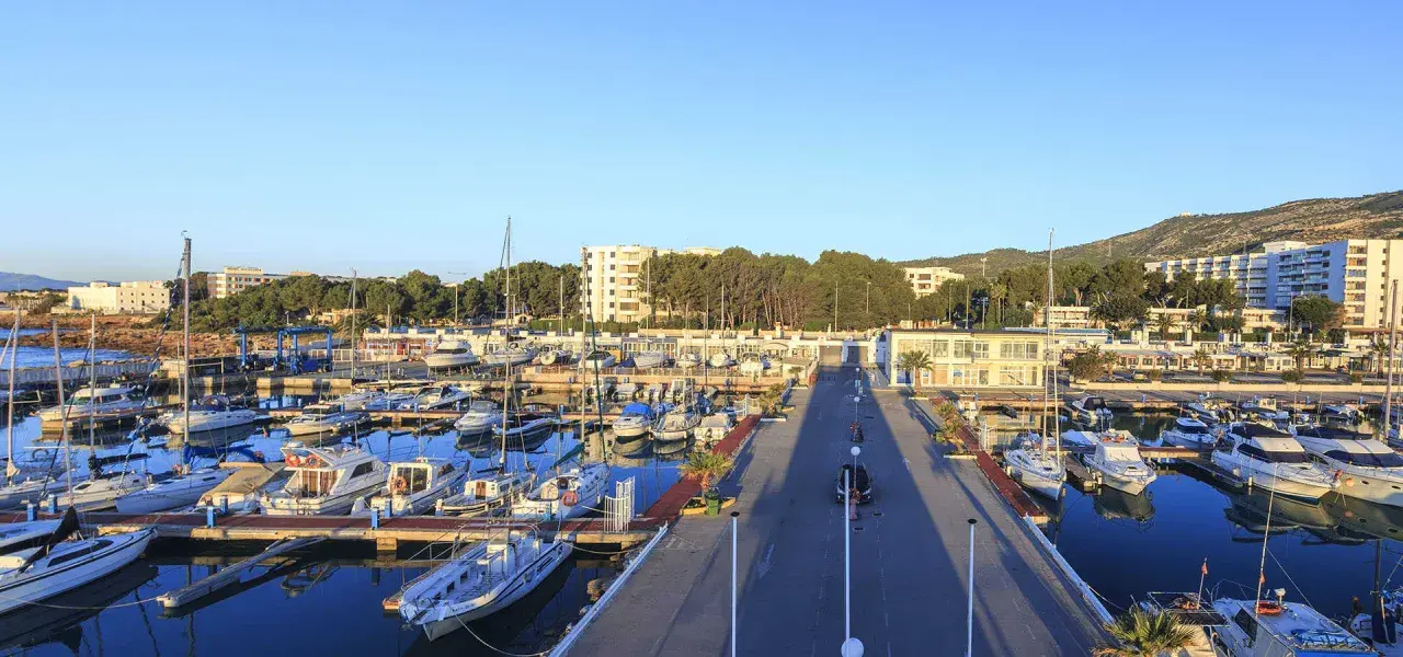 El puerto deportivo Las Fuentes, con sus barcos amarrados y el mar azul, se extiende bajo un cielo despejado.
