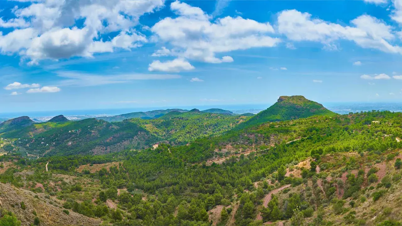 Paisaje montañoso verde con el mar al fondo. Ideal para camping en la Sierra Calderona.