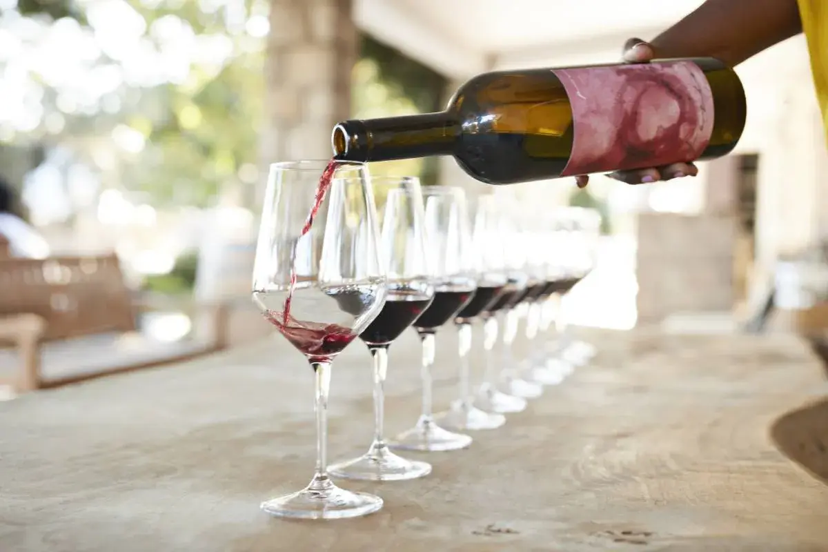 Una persona sirve vino tinto en copas para una degustación en Valencia.