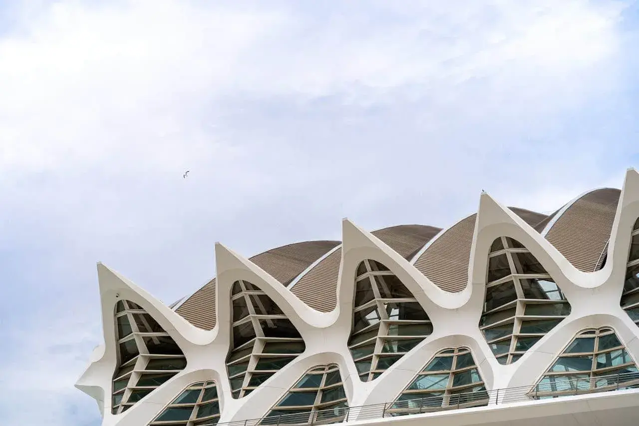 El Museo de las Ciencias de Valencia, con su arquitectura futurista y sus ventanas en forma de ojo, se alza bajo un cielo nublado.