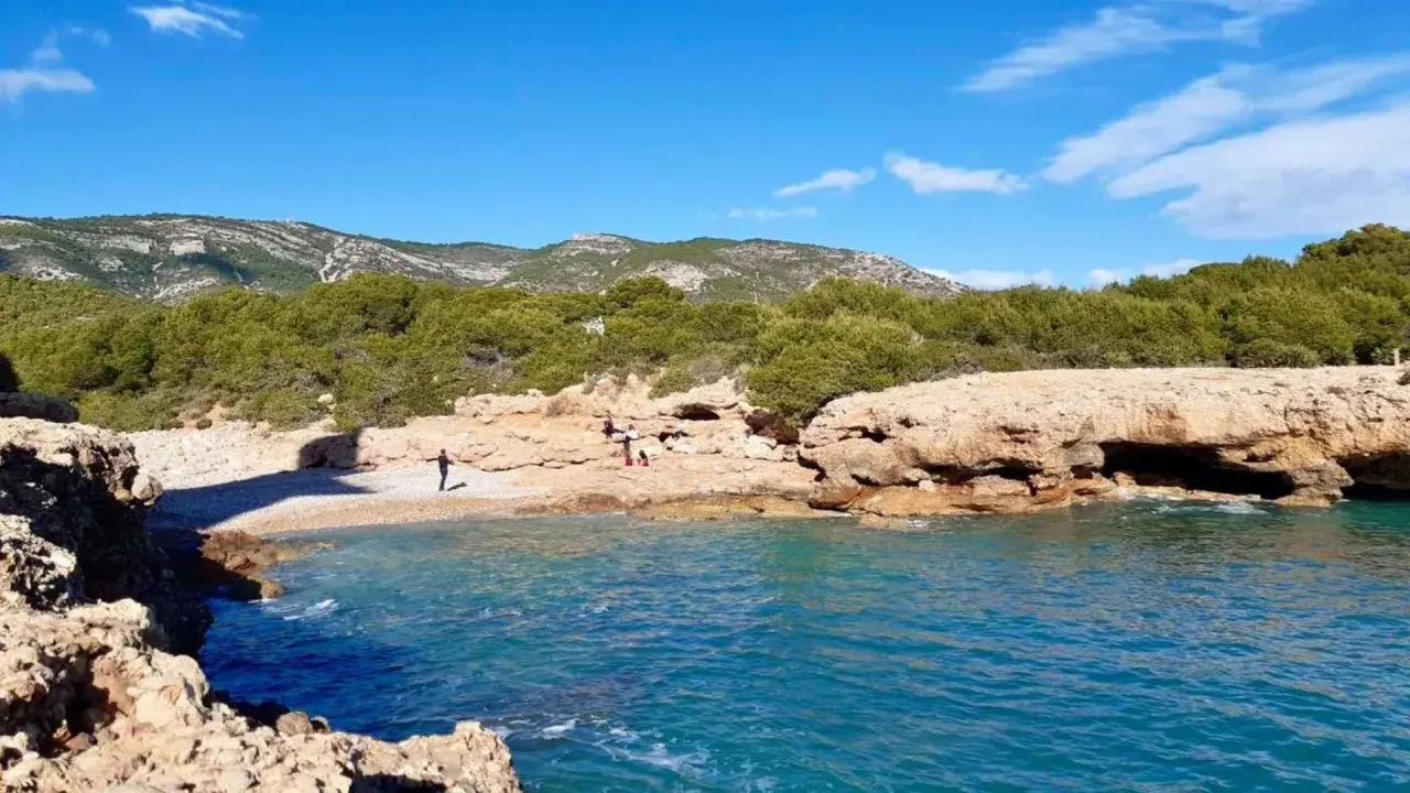 La cala mundina, con sus aguas turquesas y rocas doradas, invita a disfrutar de un día soleado. Un rincón idílico para desconectar.