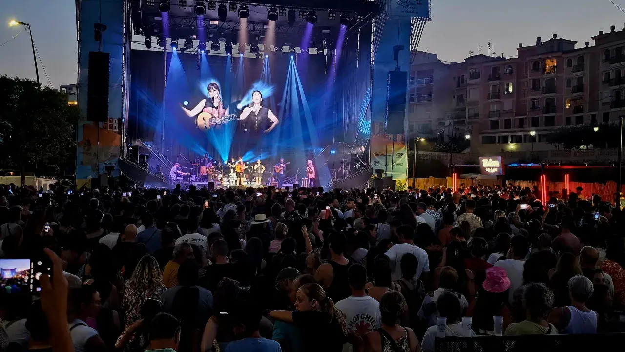 Multitud disfrutando del maror fest, con un gran escenario iluminado y artistas tocando.