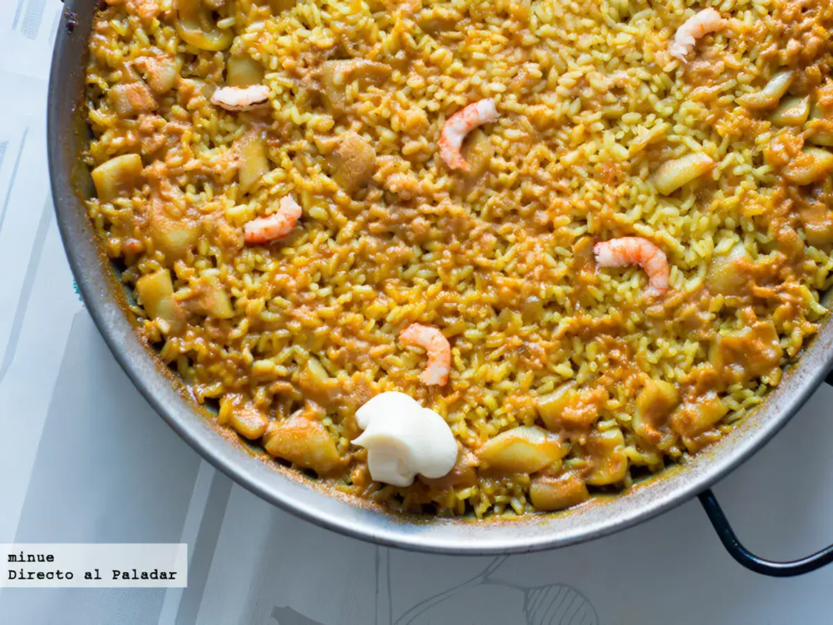 Un delicioso arroz a banda que lleva gambas y trozos de patata, servido en paellera con una cucharada de alioli.