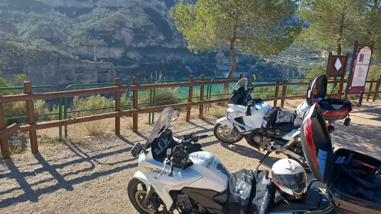 Dos motos blancas listas para explorar las **rutas en moto Comunidad Valenciana**, con un paisaje de cañón y embalse al fondo.