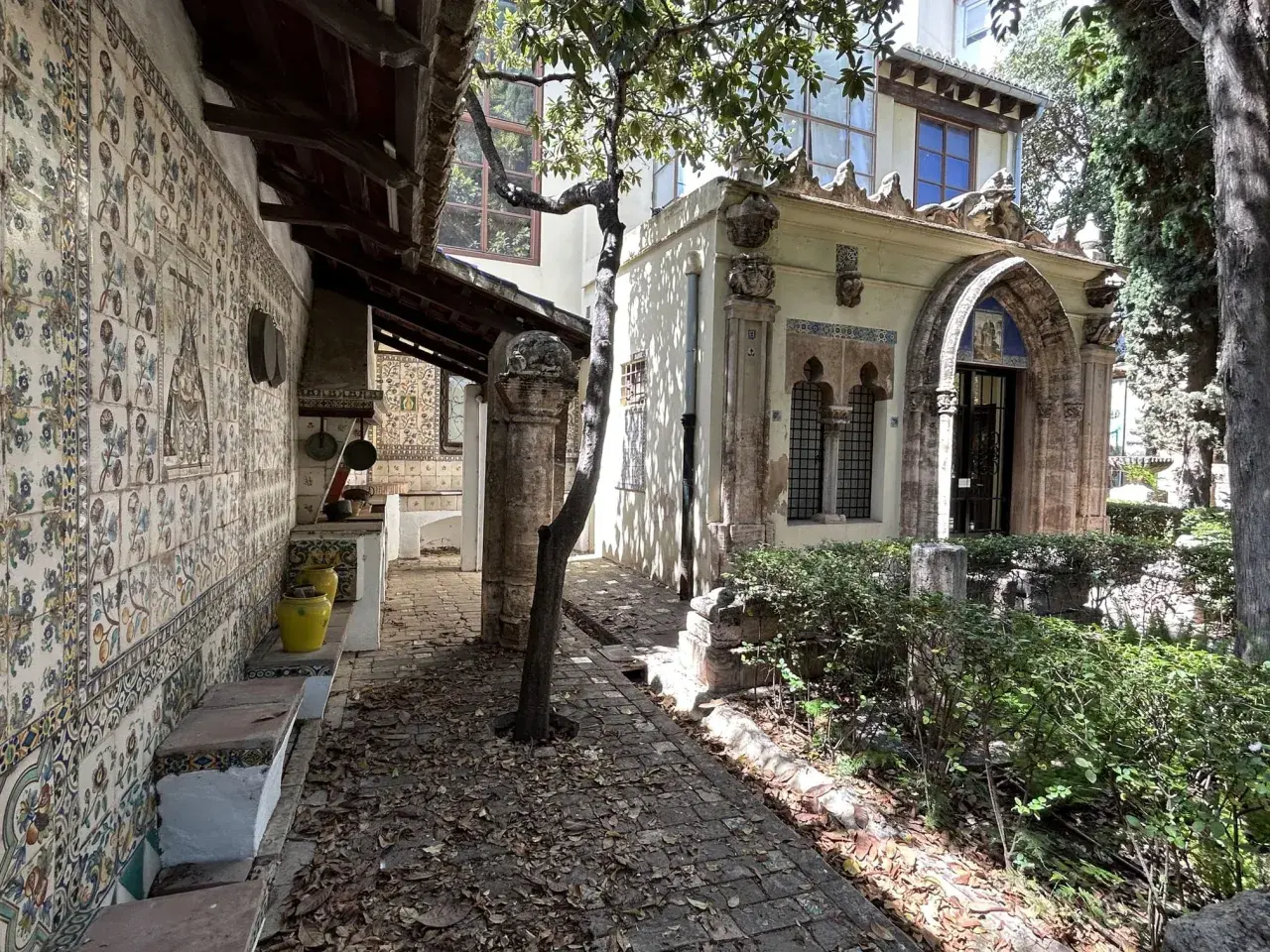 El patio de la casa museo Benlliure, con sus azulejos coloridos, bancos de piedra y un árbol frondoso, invita a pasear.