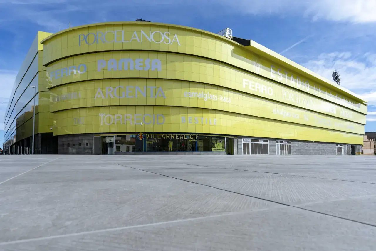 El **estadio La Cerámica** de color amarillo brillante, con el nombre del club Villarreal CF visible.