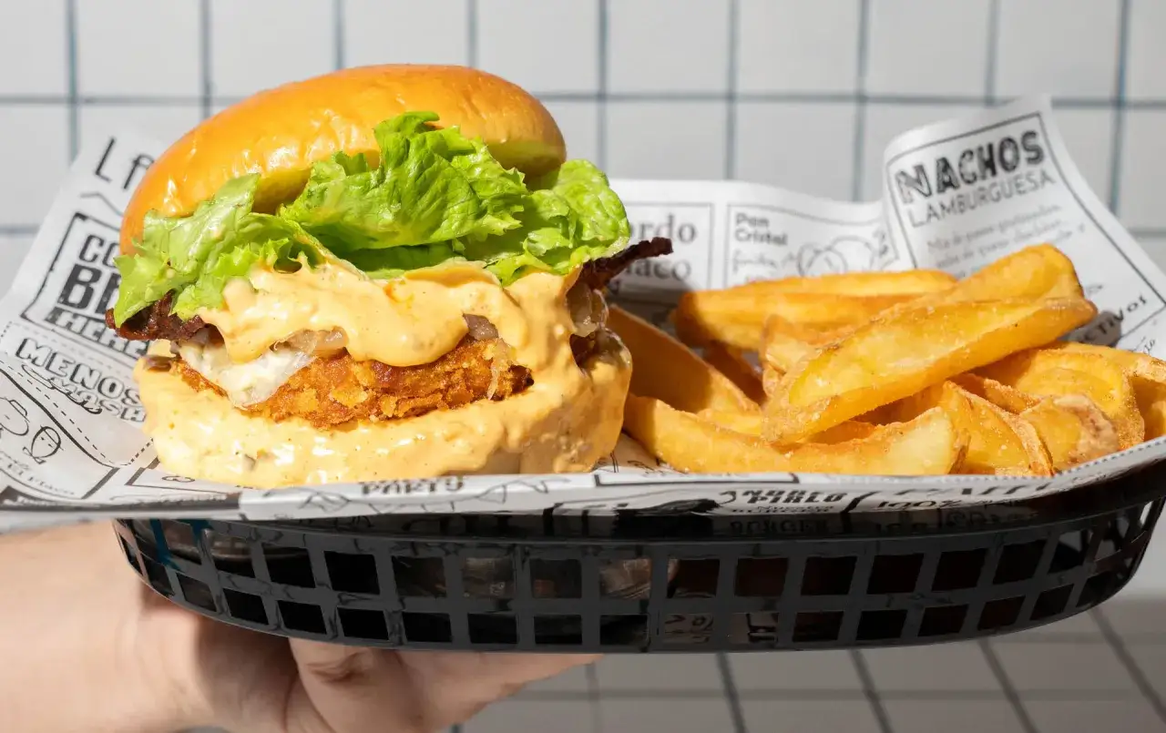 Hamburguesa jugosa con lechuga fresca y salsa cremosa, acompañada de patatas fritas crujientes. ¡Una combinación que vale cien valencia!