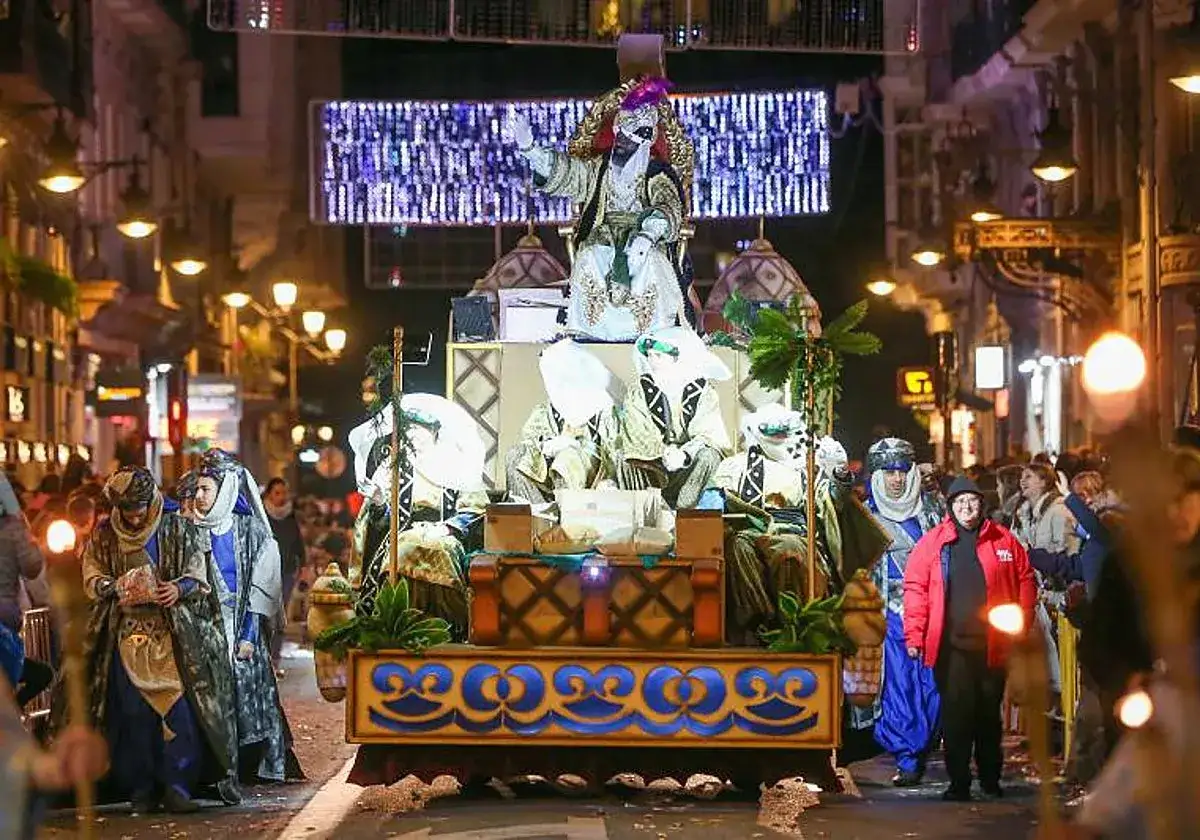 La cabalgata de Reyes en Valencia ilumina la noche con un desfile mágico. Reyes Magos en carrozas, rodeados de luces y público expectante.