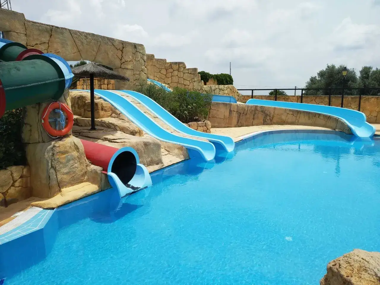 Toboganes azules y una piscina en el Segobriga Park. ¡Diversión acuática garantizada!