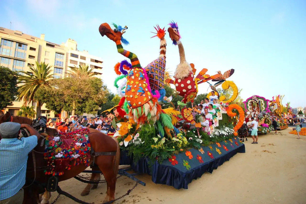 Carrozas coloridas y gente celebrando la batalla de las flores Valencia.