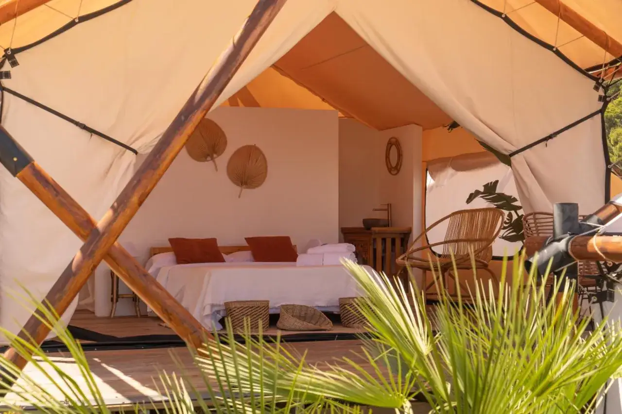Acogedora tienda de campaña en dreamsea mediterranean camp. Cama confortable, sillones de mimbre y decoración natural.
