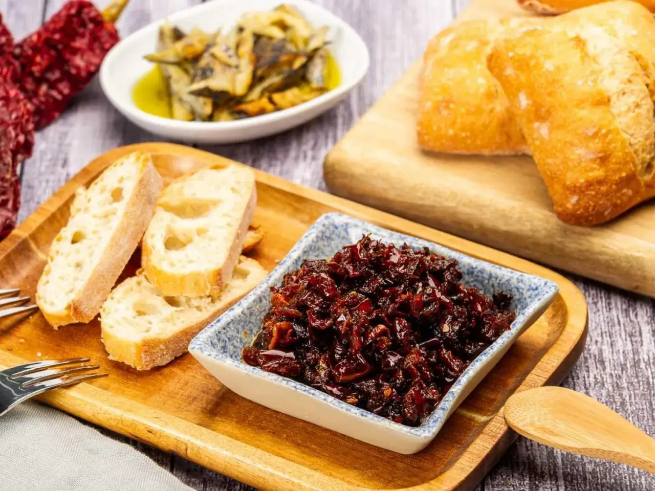 Un plato con pan r&uacute;stico, pimientos secos y un cuenco de pericana receta, un delicioso pat&eacute; de pimientos y bacalao.