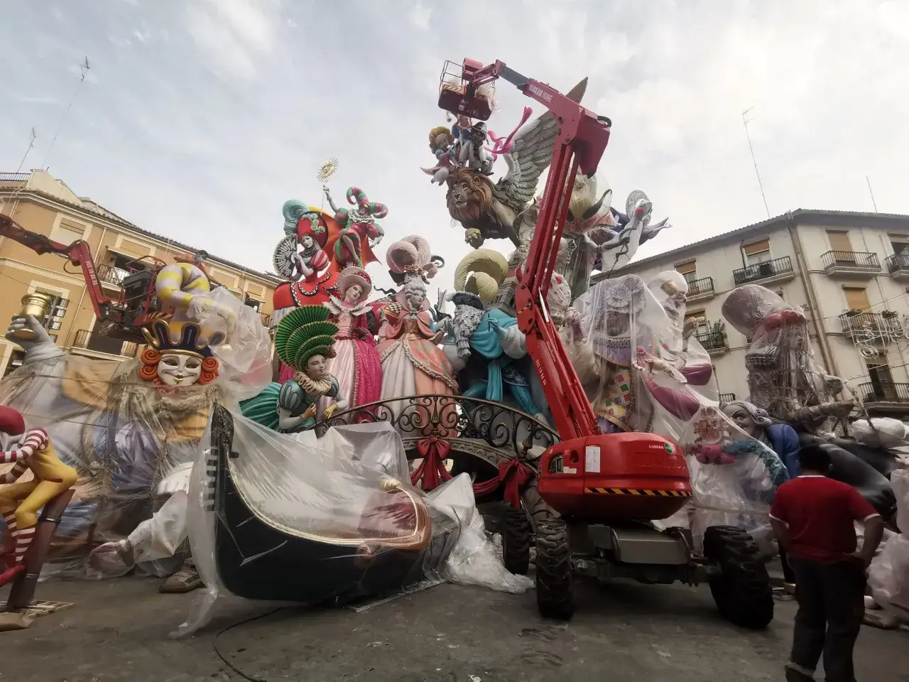 Montaje de ninots gigantes para las Fallas. Una gr&uacute;a eleva figuras cubiertas, prepar&aacute;ndose para cuando es la planta final.