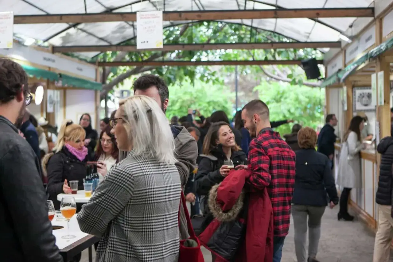 Gente disfrutando en la feria del vino Valencia, con copas y buen ambiente.