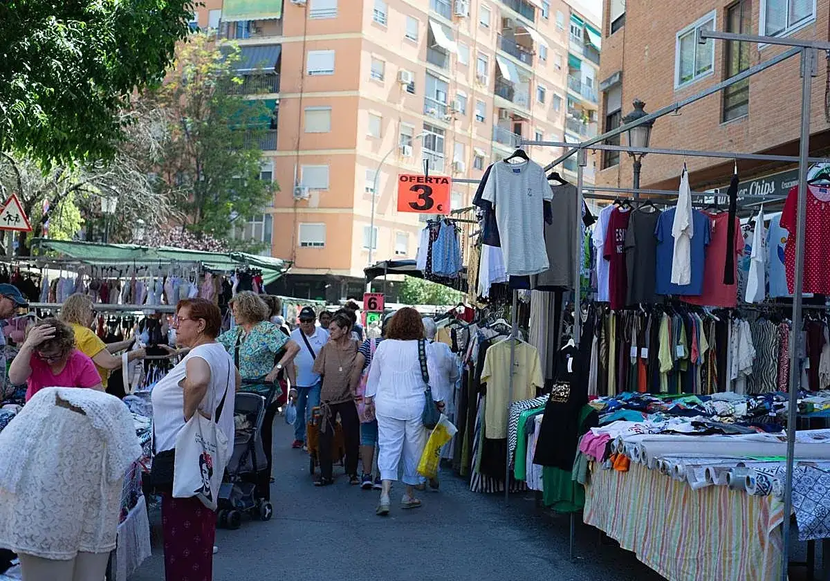 Gente comprando ropa en puestos del mercado de Torrefiel. Ofertas de 3€.