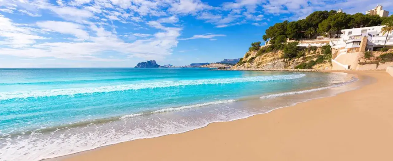 La cala el Portet, con su arena dorada y aguas turquesas, invita a soñar con un día perfecto bajo el sol mediterráneo.
