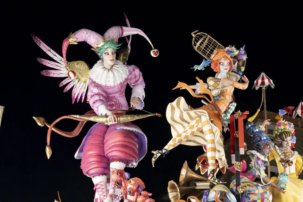 Figuras coloridas de las mejores Fallas de Valencia, con un buf&oacute;n con arco y una mujer con p&aacute;jaros.