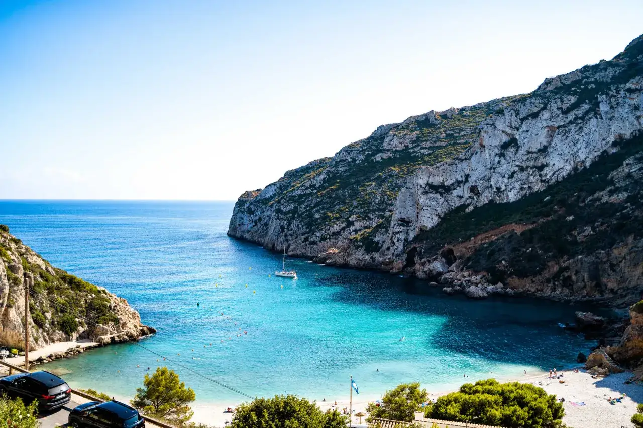 Bahía de aguas turquesas con acantilados, una cala preciosa en la costa de Alicante.