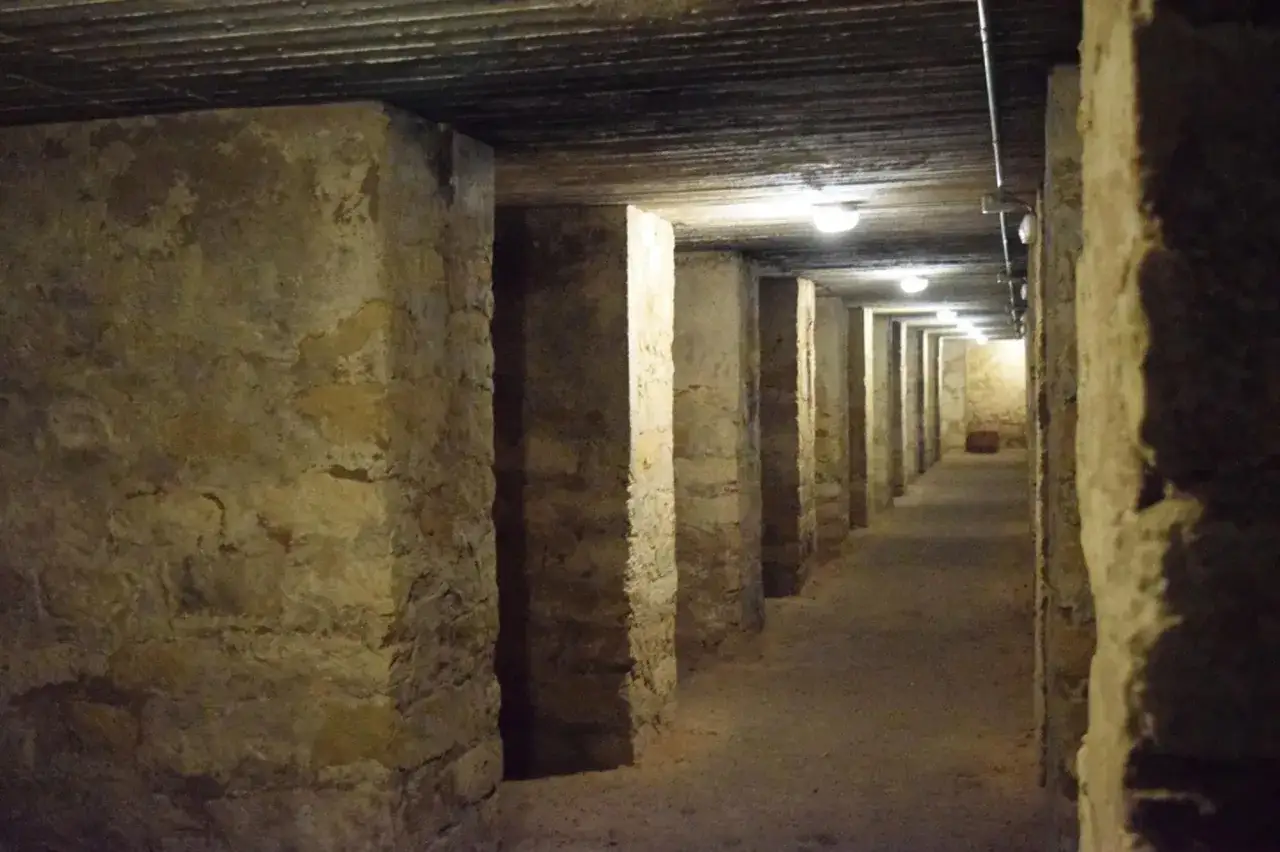 Pasillo subterráneo con pilares de piedra, vestigio de la guerra civil alicante.