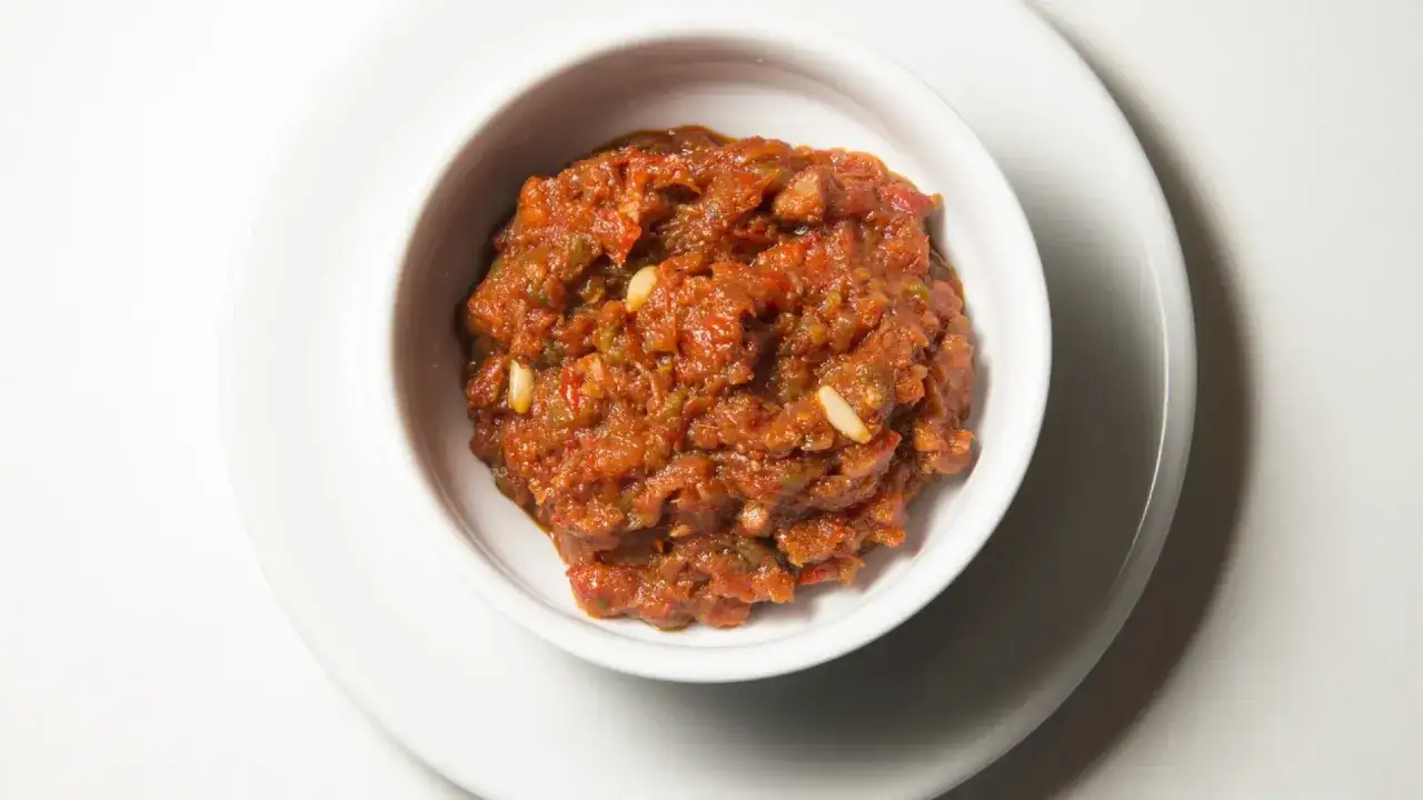 Un delicioso pisto valenciano, perfecto para saber qué comer en Valencia. Con trozos de tomate, pimiento y piñones.