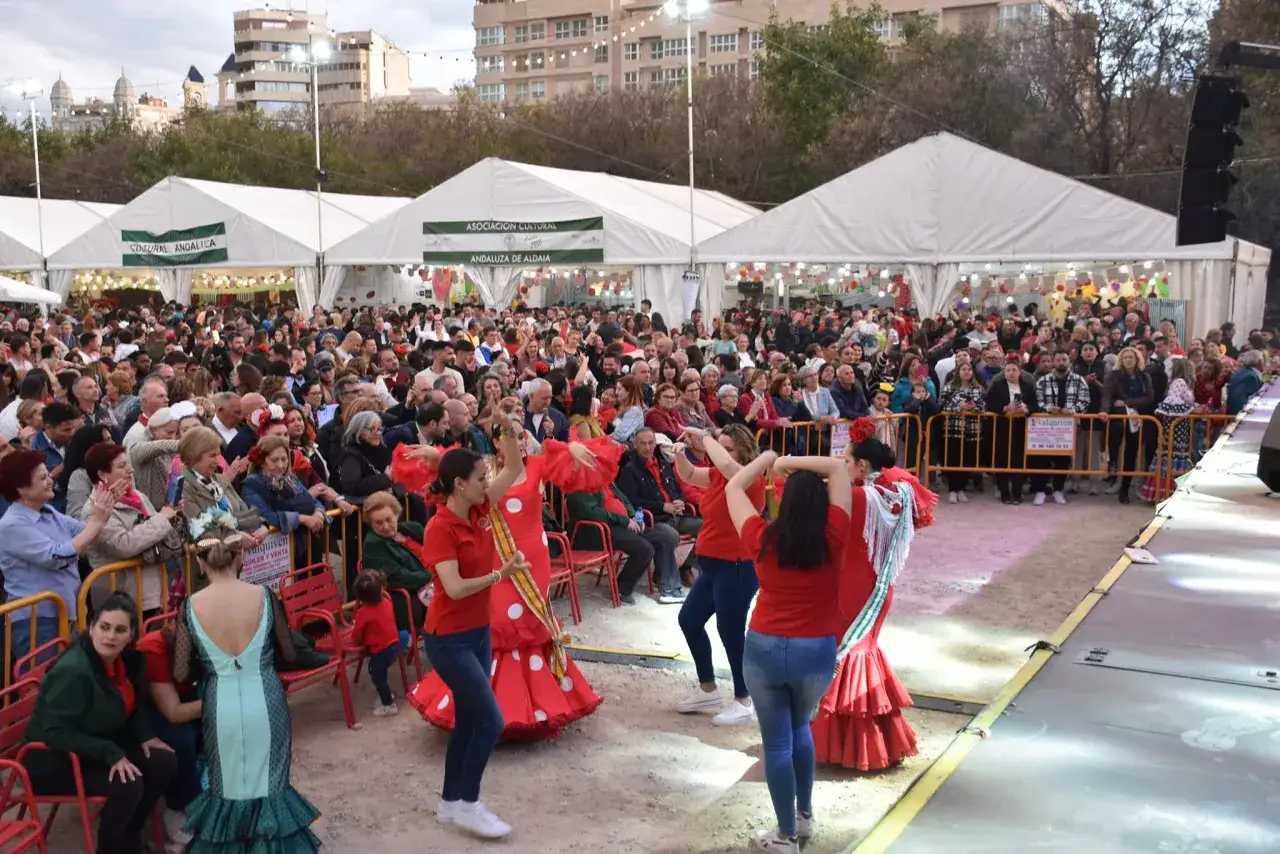 Gente disfrutando de la feria de abril en Valencia, con actuaciones y puestos.