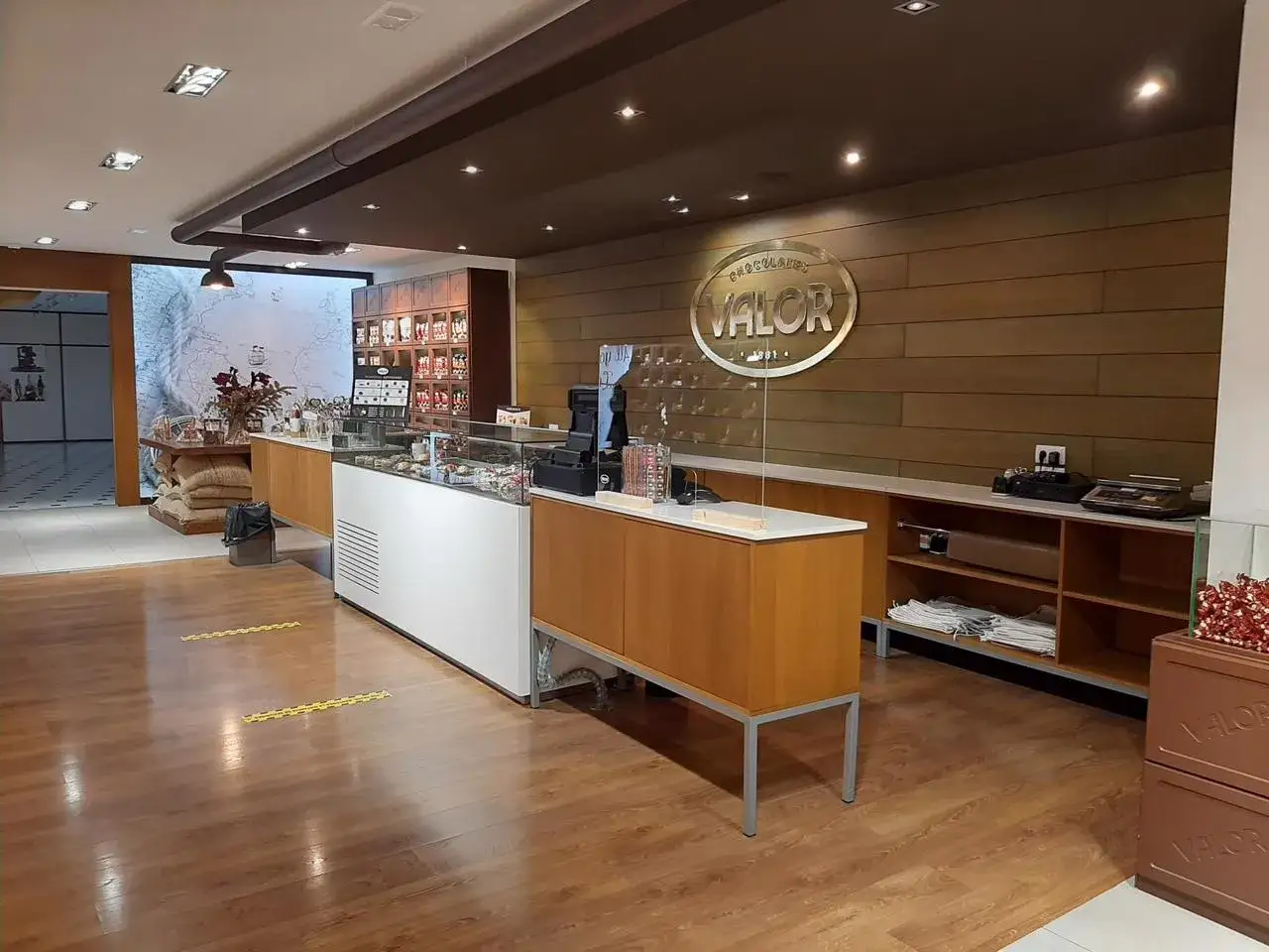 Interior de una tienda de chocolates Valor, con vitrinas exhibiendo productos y el logo de la marca.