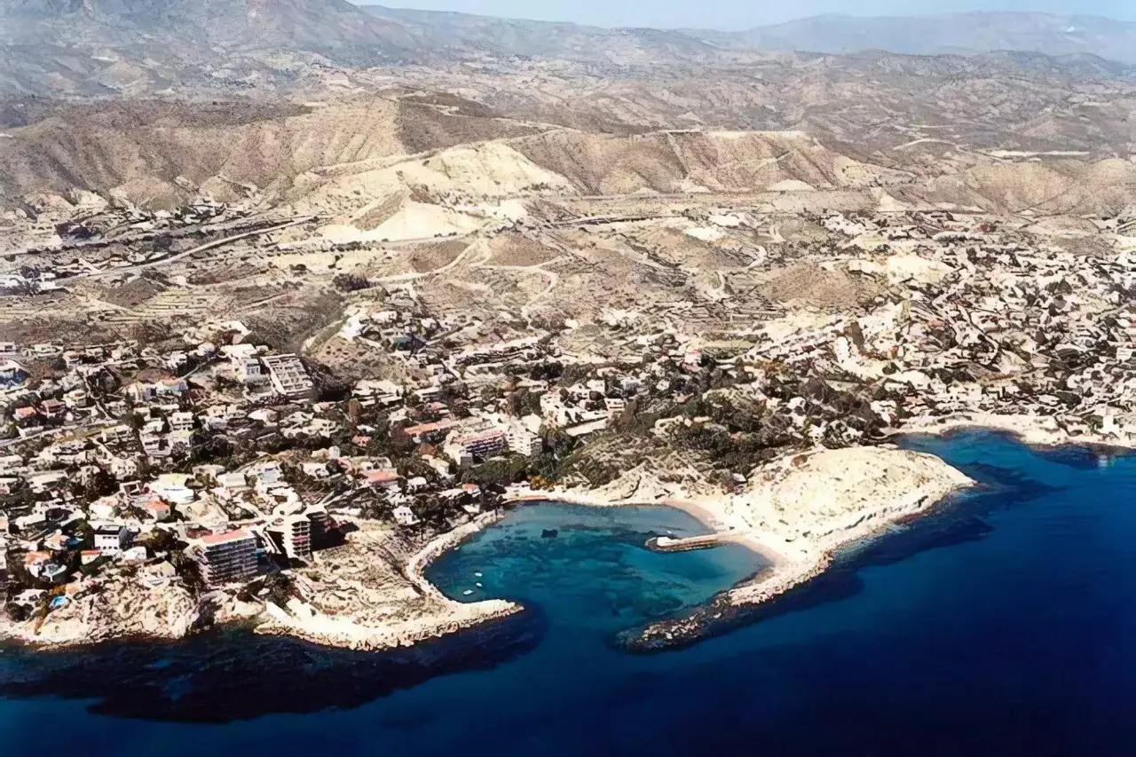 Vista aérea de la cala Coveta Fuma, con casas blancas y el mar azul intenso.